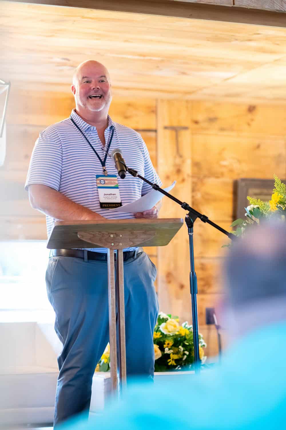 A speaker presenting from a podium at a professional gathering