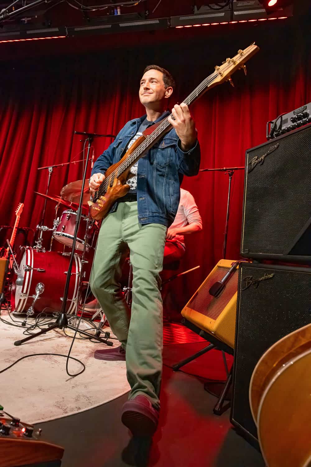 A musician performing under vivid stage lighting